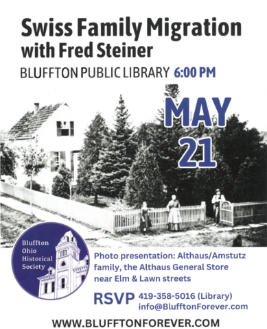 Black and white photo of a house with a white picket fence and people standing near the gate. 